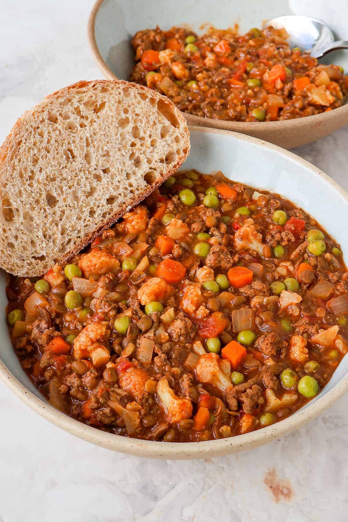 Side shot of the veggie mince served in a bowl with bread.