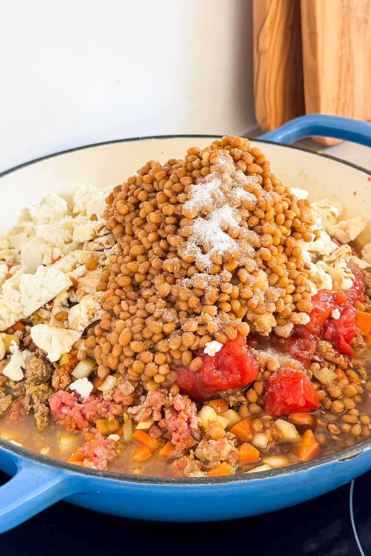 Lentils. cauliflower and canned tomatoes added to the pan.