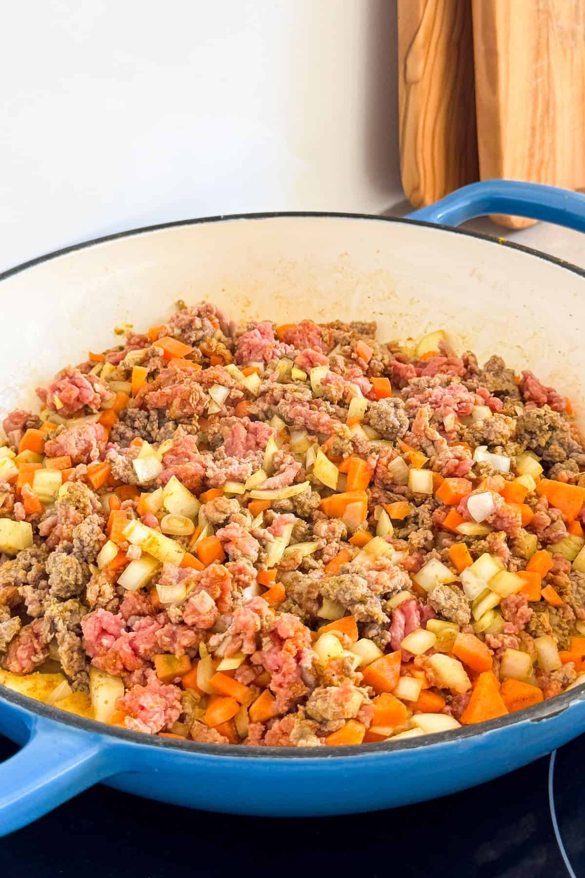 Ground mince and veggies cooking in a pan.