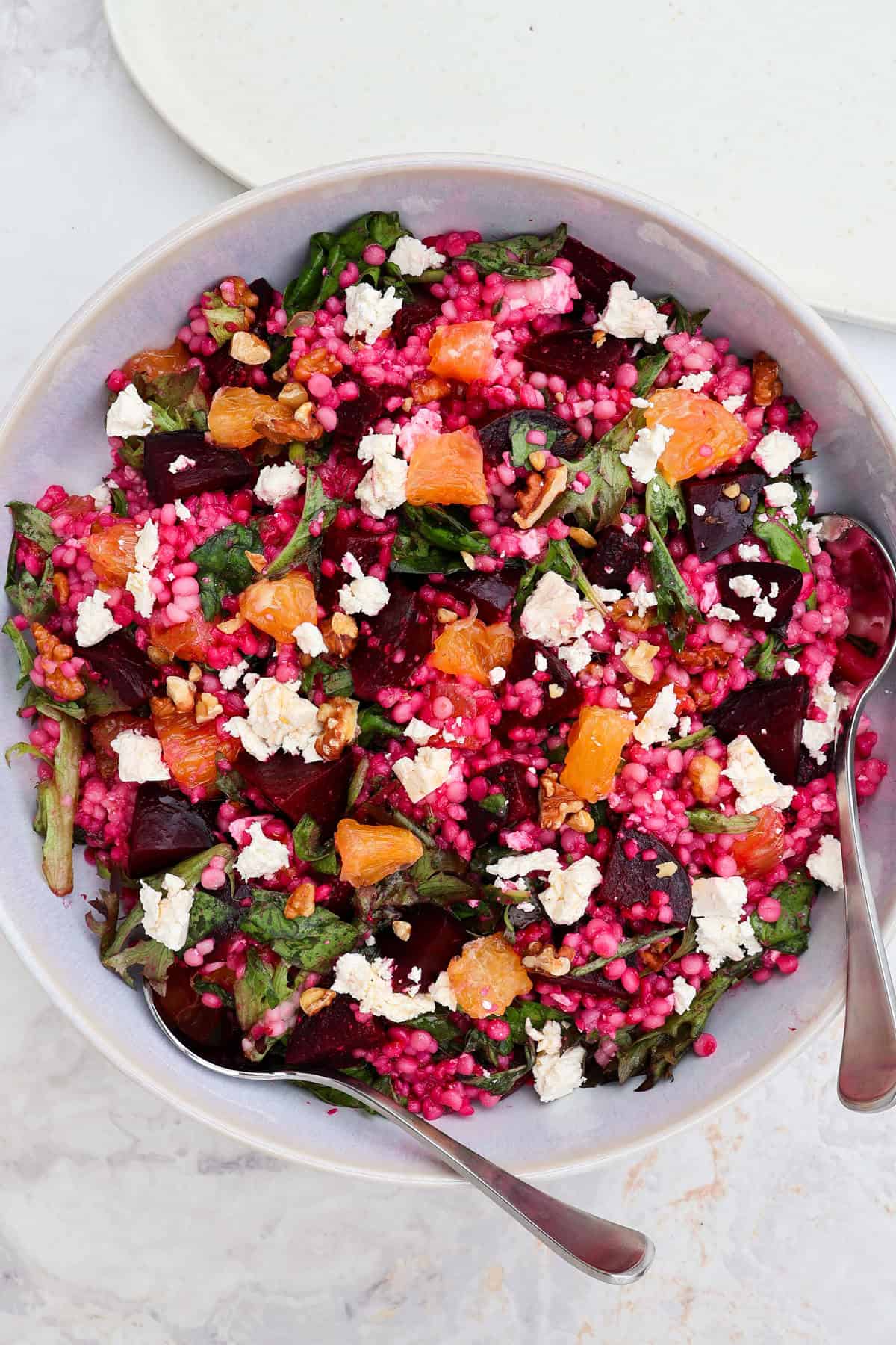 Beetroot couscous salad served in a bowl with spoons.