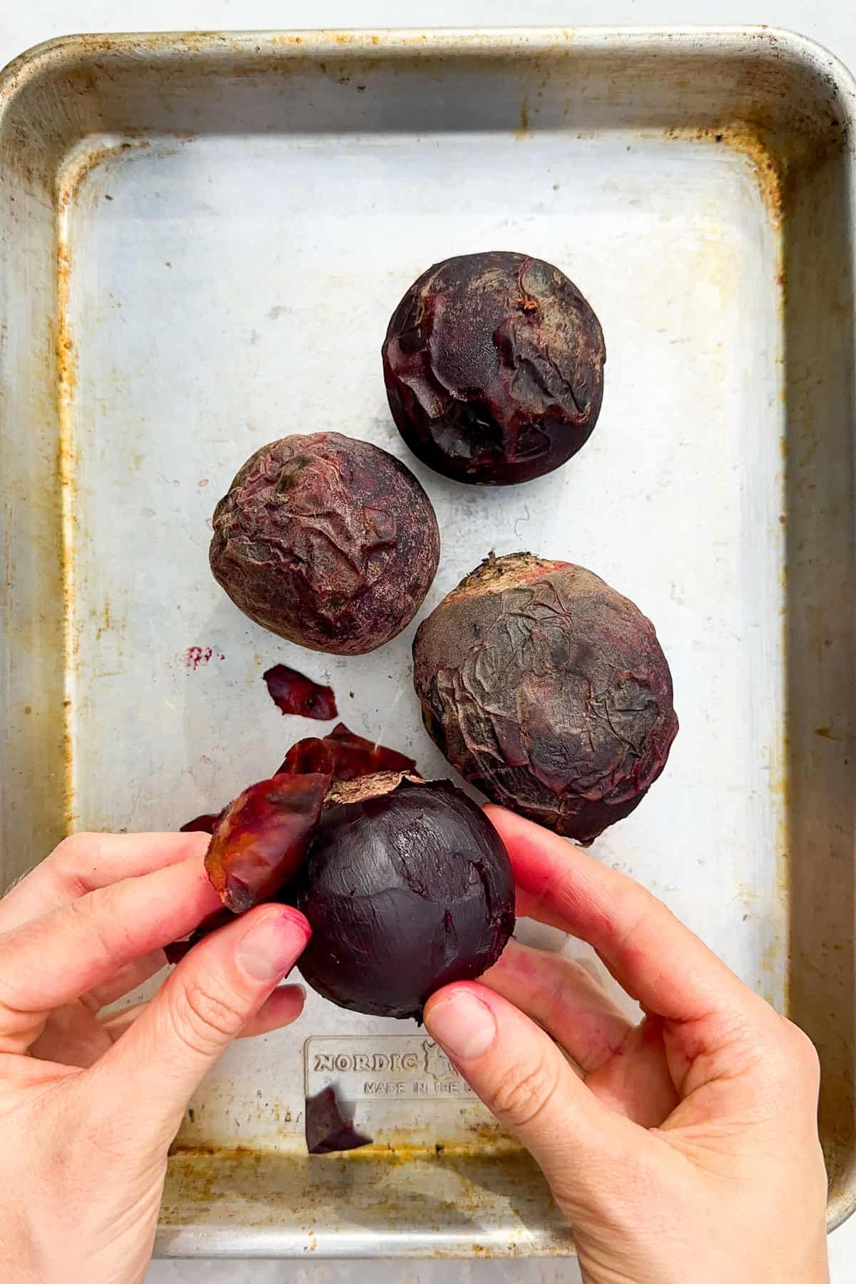Cooked beetroots being peeled.