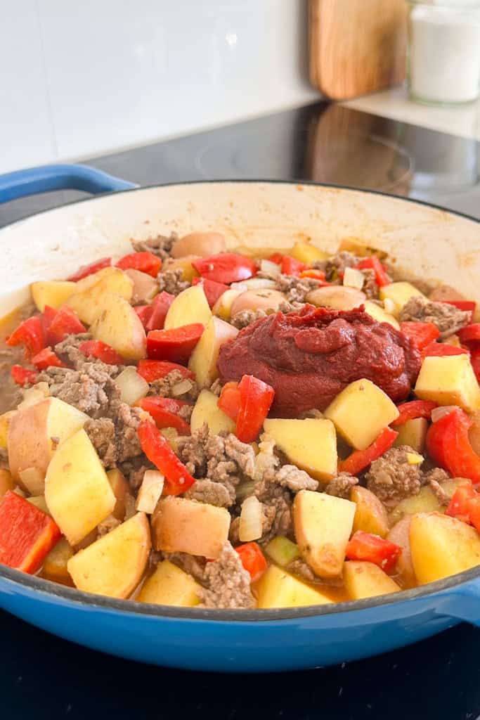 Tomato paste added to the skillet.