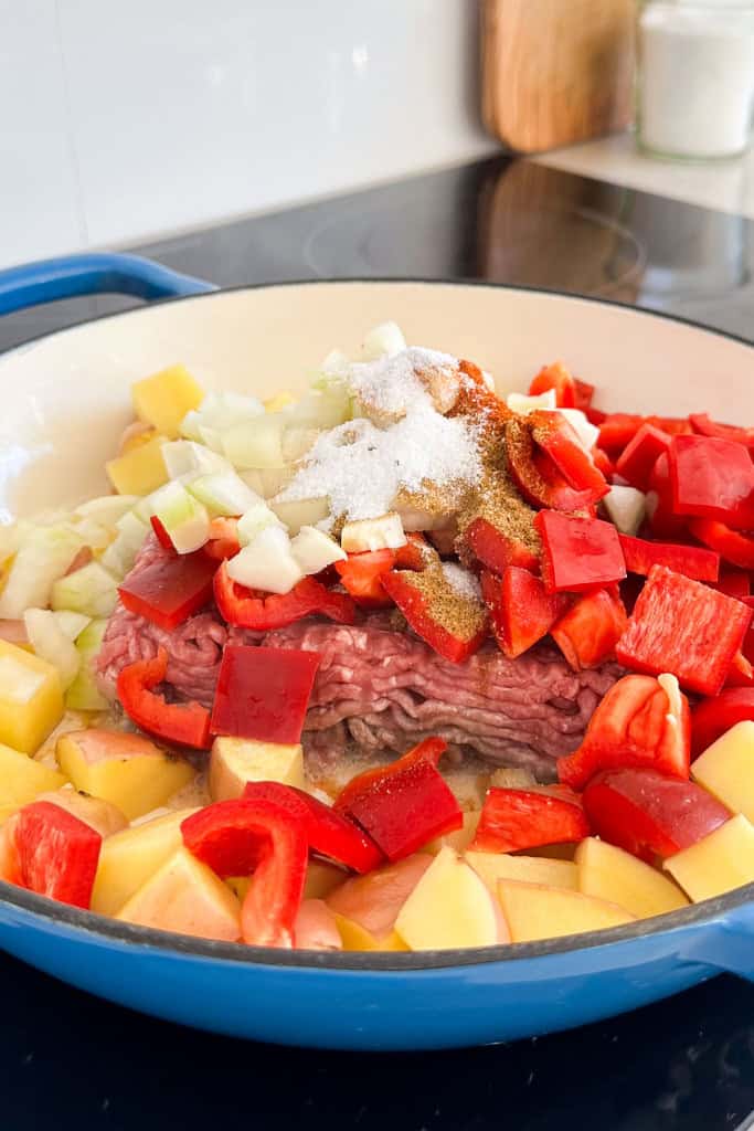 Ground beef, peppers and seasonings added to the skillet.