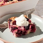 Side shot of the blackberry baked oatmeal served on a plate topped with yoghurt.