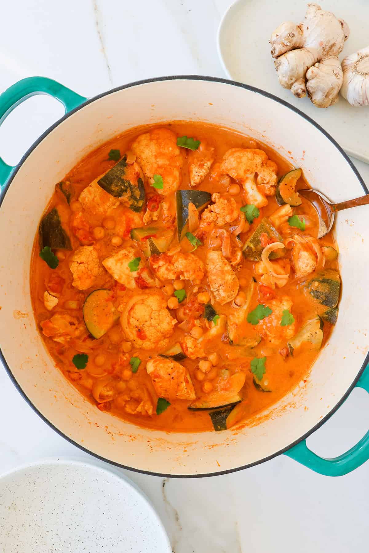 Chickpea and chickpea curry in a pot with a spoon.