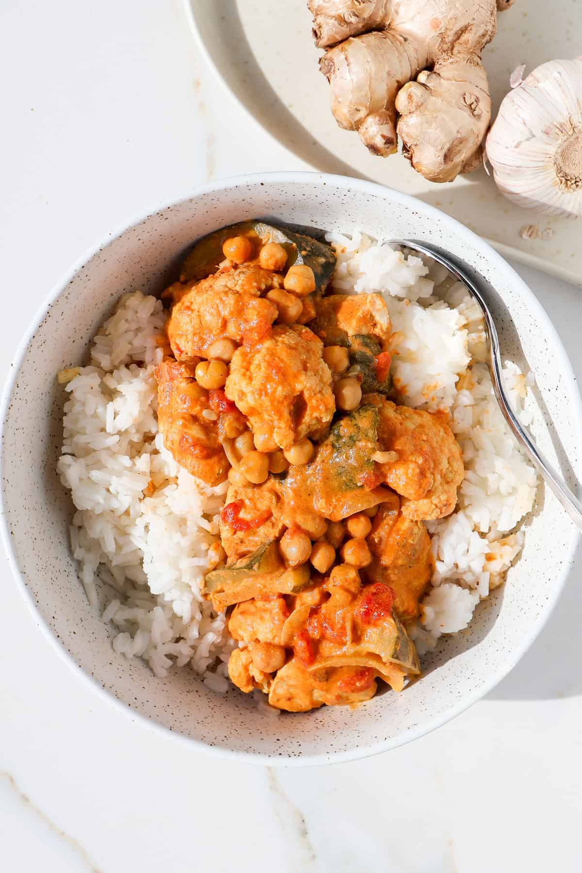 Chicken and chickpea curry served over rice in a bowl.