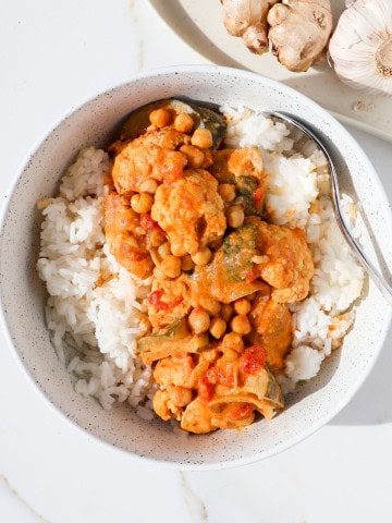 Chicken and chickpea curry served over rice in a bowl.