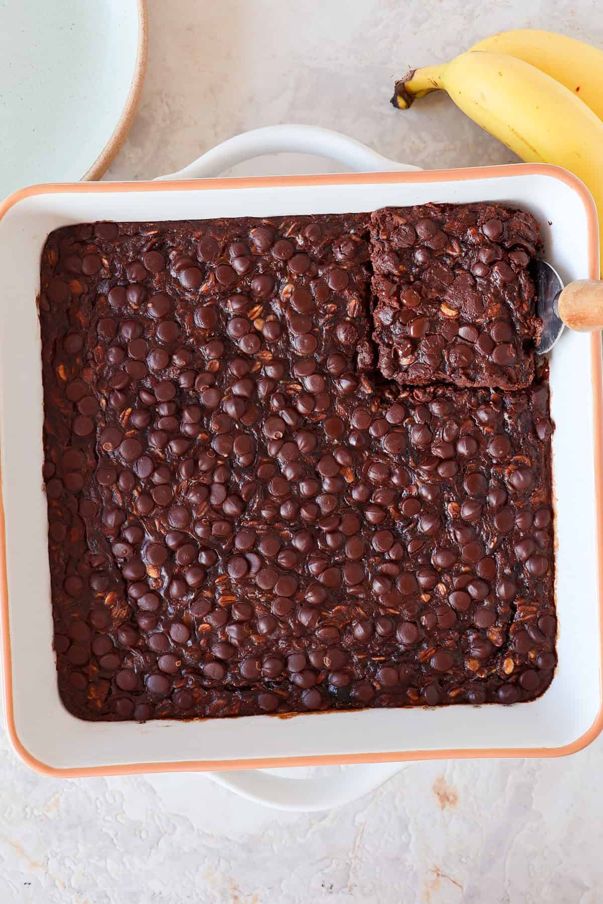 Chocolate baked oatmeal in a dish with a piece cut out.