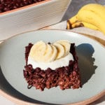 Side shot of the chocolate baked oatmeal on a plate topped with yoghurt and banana.